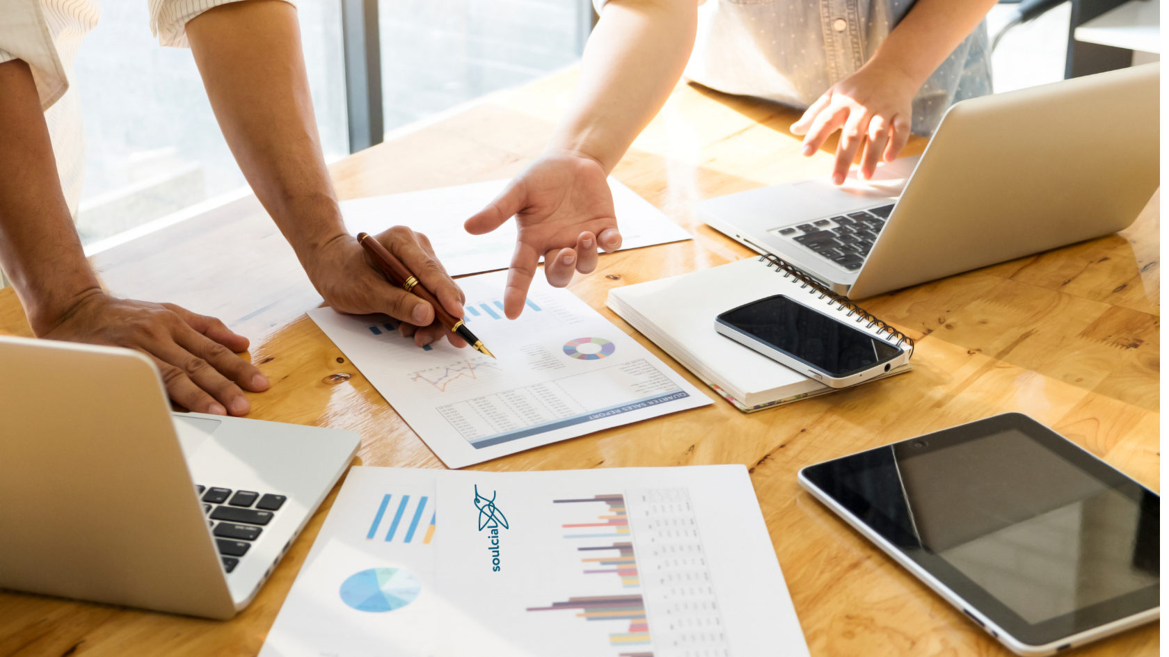 Profissionais analisando relatórios de impacto social e gráficos financeiros sobre uma mesa, com o logotipo da Soulcial em destaque, representando a transparência na gestão de ONGs.